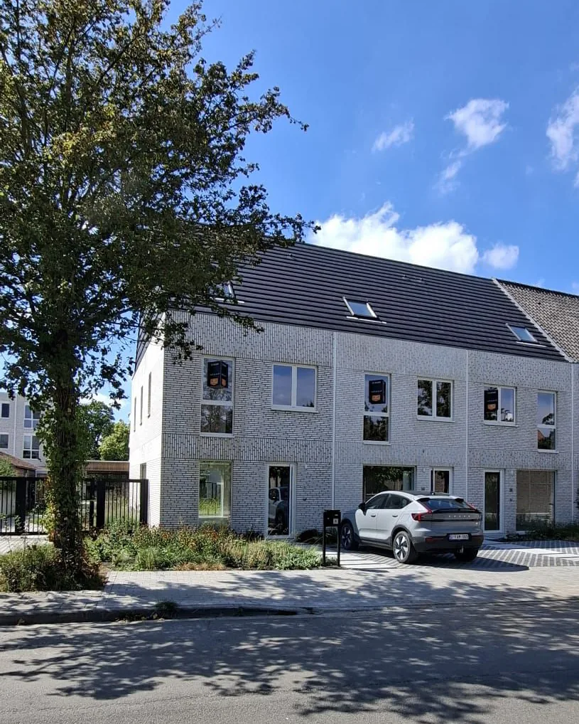Afgewerkte woningen van Morris met een boom en een zonnige lucht