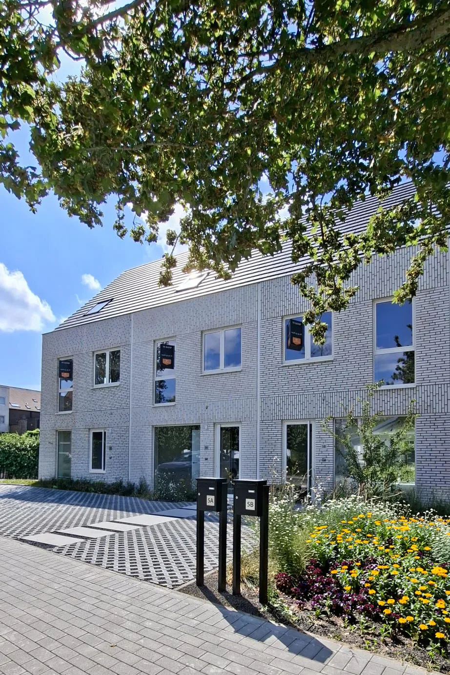 Woningen van Morris met een kiezelpad, bloemen en een groene omgeving