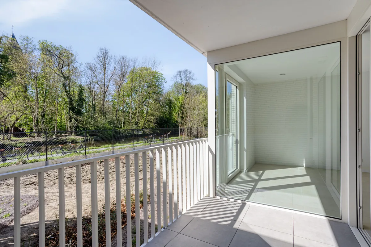 Terras met wit balustrade en zicht op de bomen